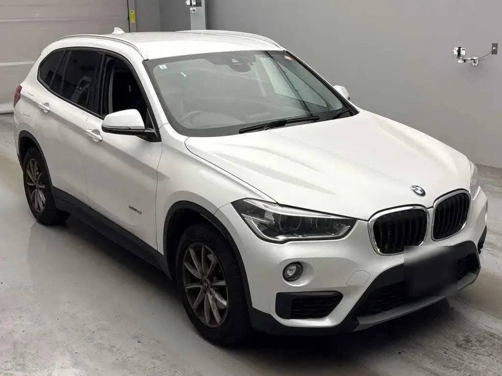 Белый BMW X1 на стоянке аукциона TAA Yokohama